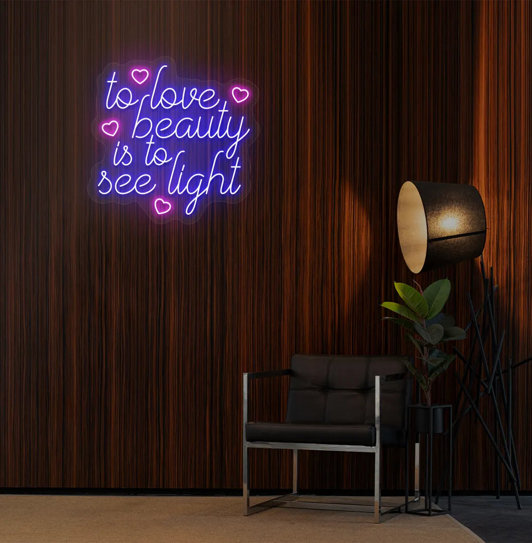 Image of a "To love beauty is to see light" neon sign in blue color on salon wall decor.