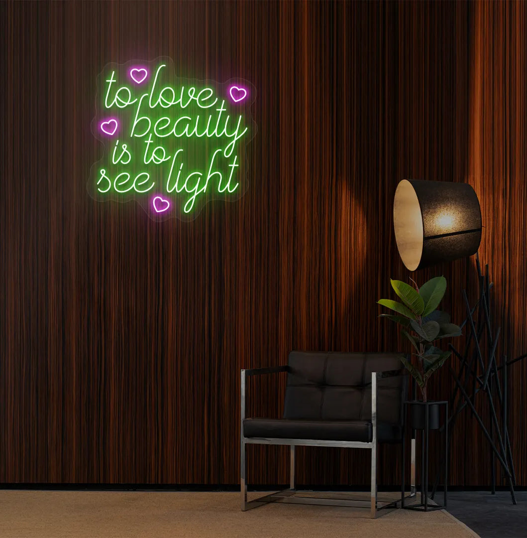 Green "to love beauty is to see light" LED neon sign for beauty studio setup.