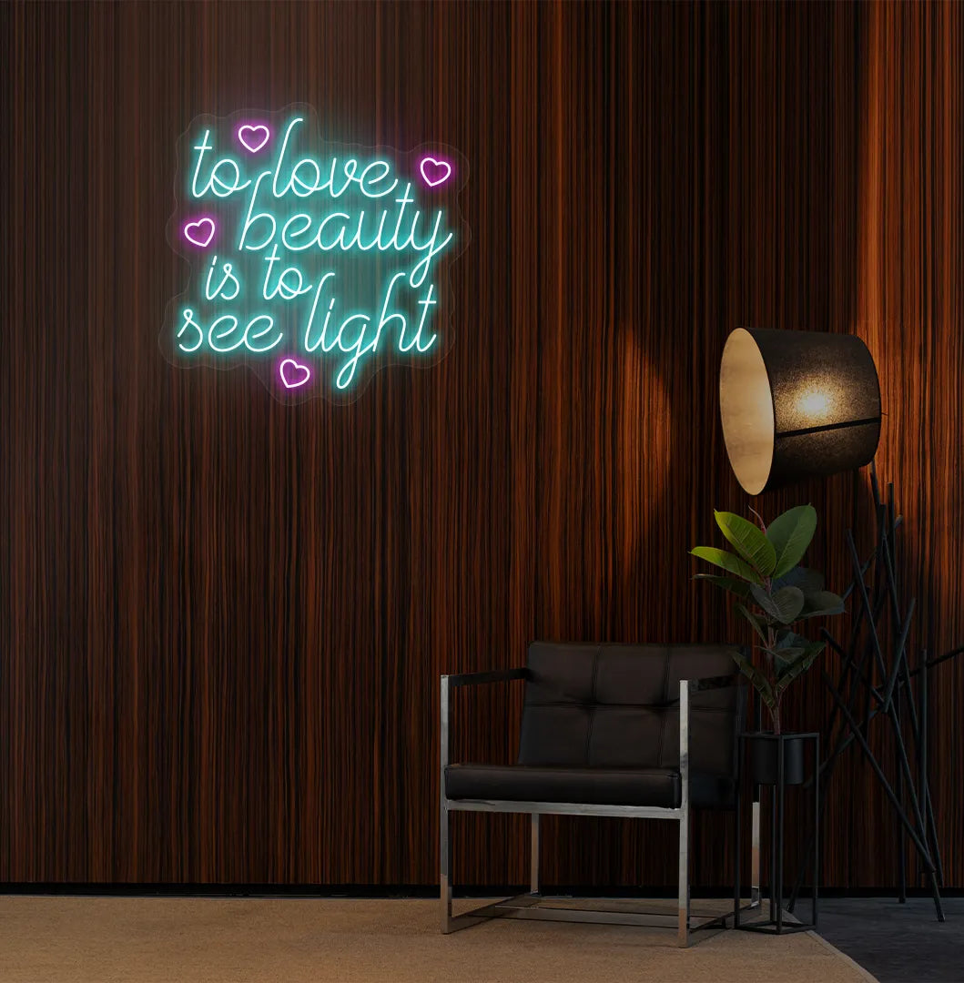 Image of a "To love beauty is to see light" neon sign in ice blue color on salon wall decor.