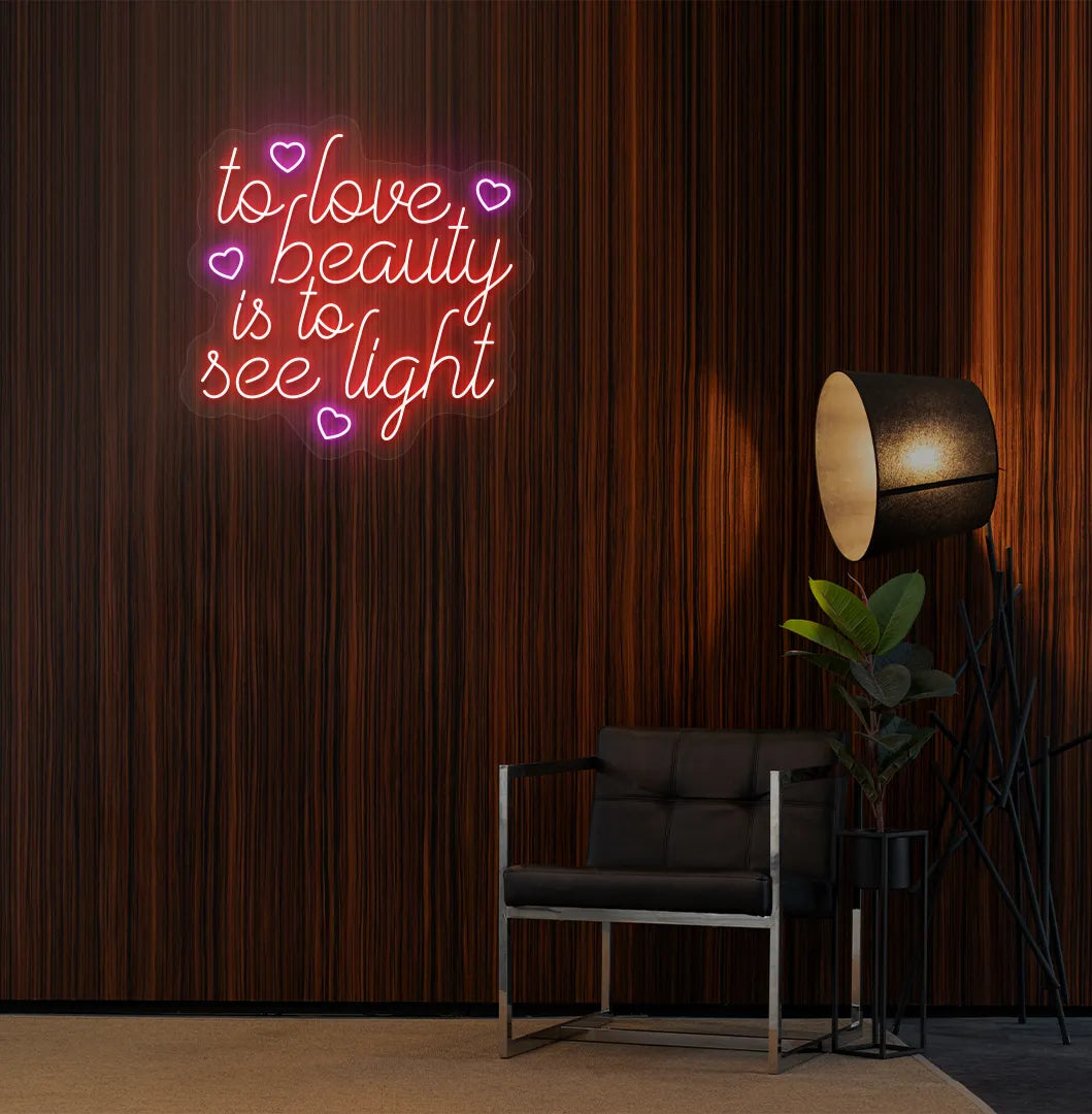 Image of a "To love beauty is to see light" neon sign in red color on salon wall decor.