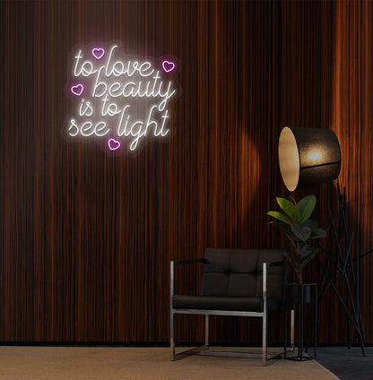 Image of a "To love beauty is to see light" neon sign in white color on salon wall decor.
