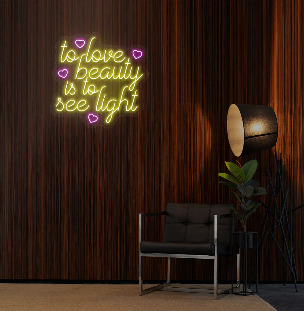 Yellow "to love beauty is to see light" LED neon sign for beauty studio setup.