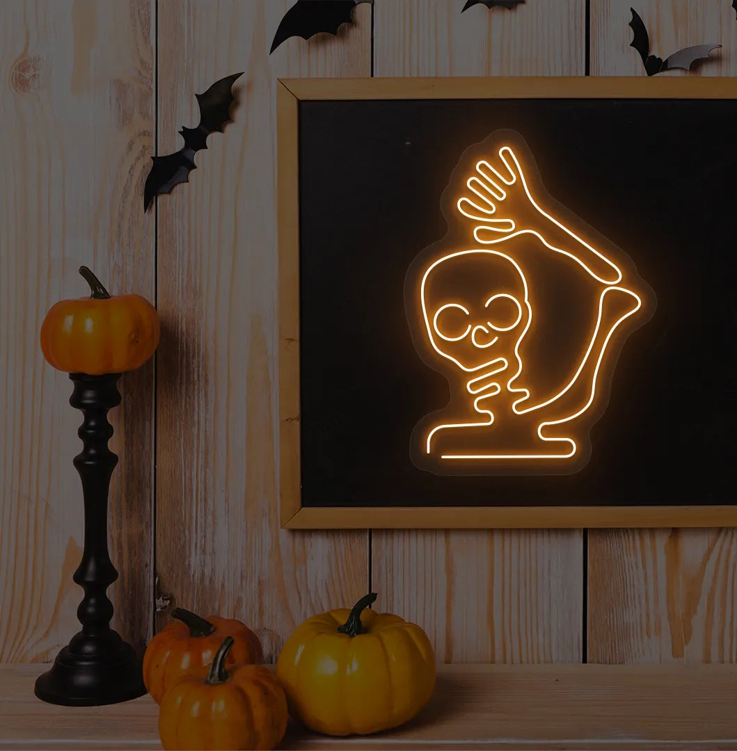Waving Skeleton Orange Neon Sign creating a spooky glow on a Halloween themed wall.