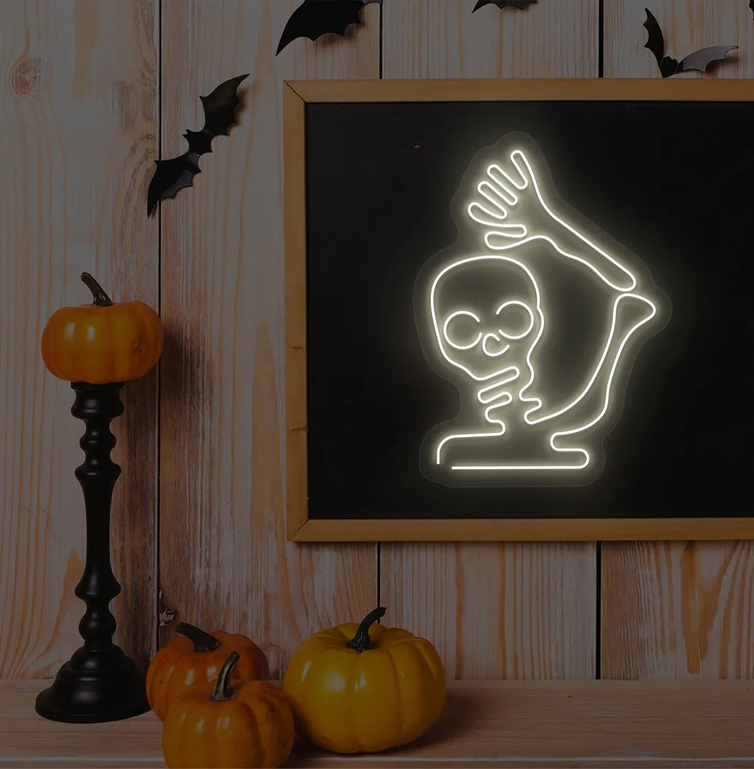 Waving Skeleton Warm White Neon Sign creating a spooky glow on a Halloween themed wall.