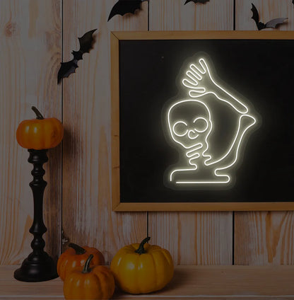 Waving Skeleton Warm White Neon Sign creating a spooky glow on a Halloween themed wall.