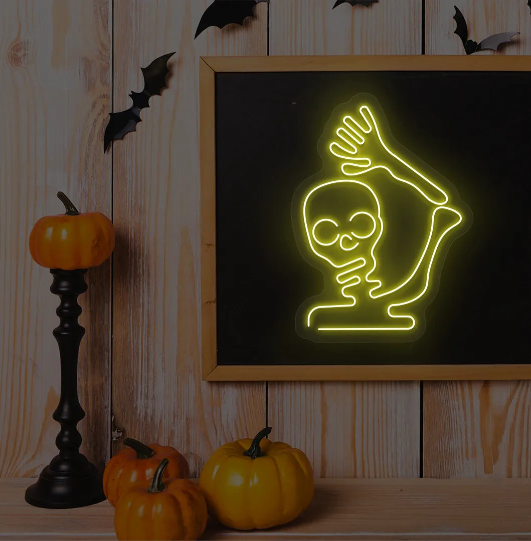 Waving Skeleton Yellow Neon Sign creating a spooky glow on a Halloween themed wall.