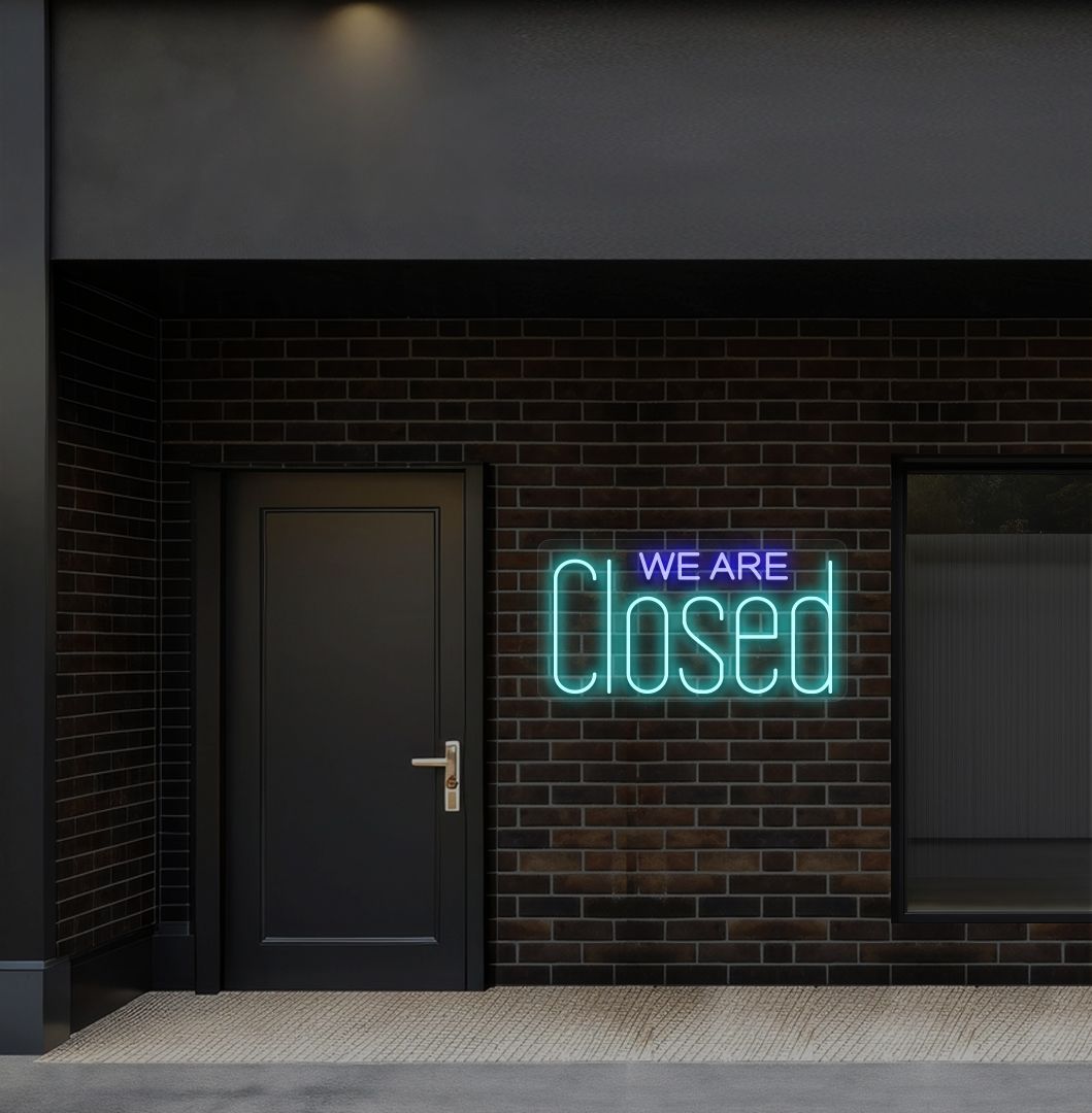 Image of a we are closed LED neon sign glowing on shop exterior wall in ice blue color.