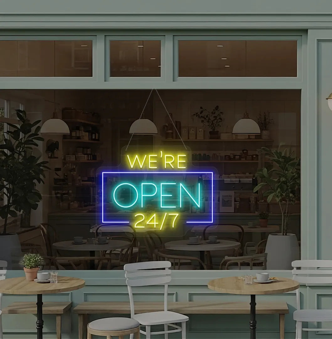 Stylish We Are Open 24/7 neon sign mounted on coffee shop glass door in ice blue color.