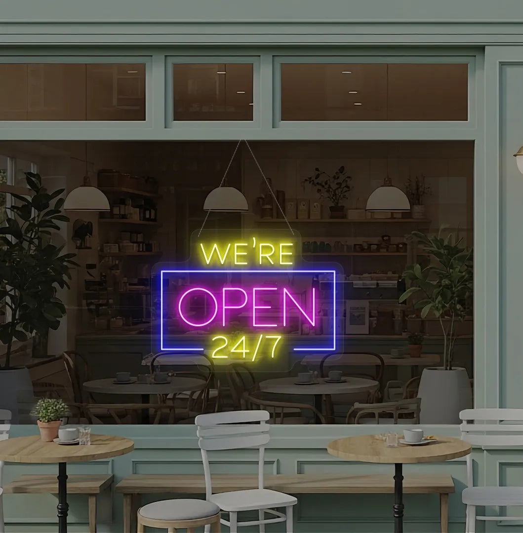 Stylish We Are Open 24/7 neon sign mounted on coffee shop glass door in pink color.