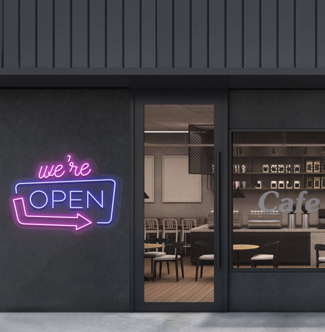 Image of a "We're Open" LED neon sign mounted on a cafe exterior wall with an arrow icon in blue color.