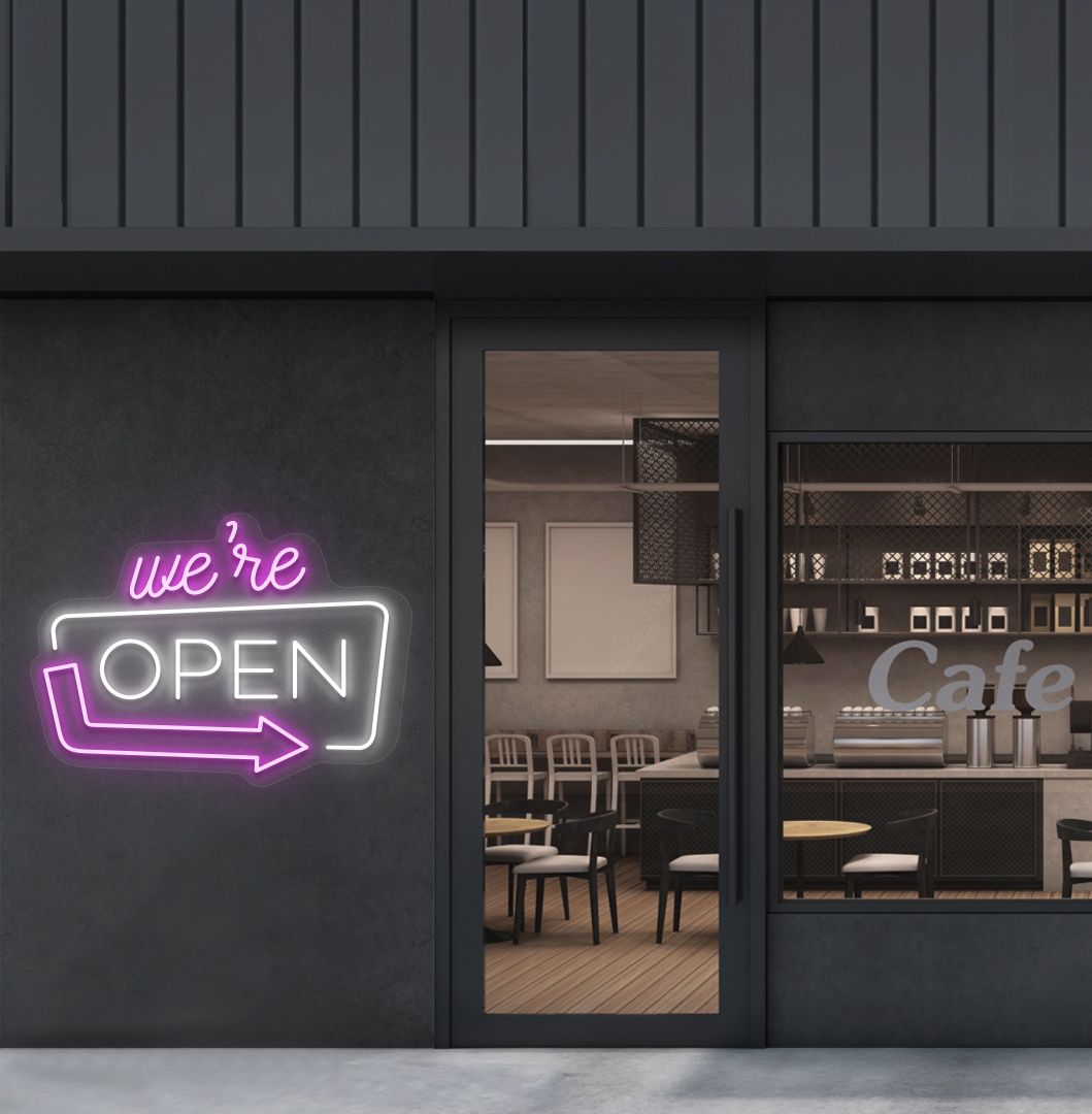 Image of a "We're Open" LED neon sign mounted on a cafe exterior wall with an arrow icon in white color.