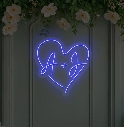 wedding initials neon sign glowing blue on wedding backdrop.