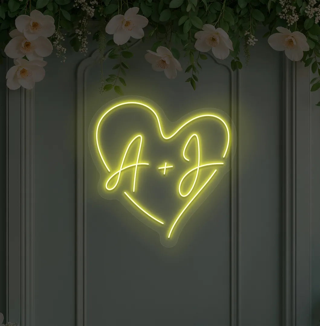 Image of a wedding initials neon sign glowing yellow on decorative wall.