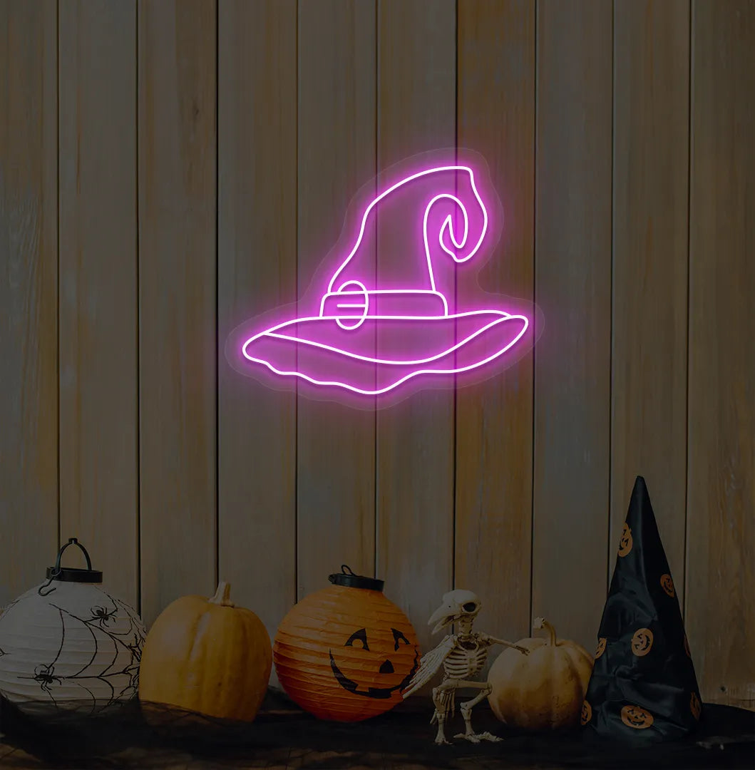 Witch Hat Neon Sign illuminated in pink on a spooky Halloween themed wall