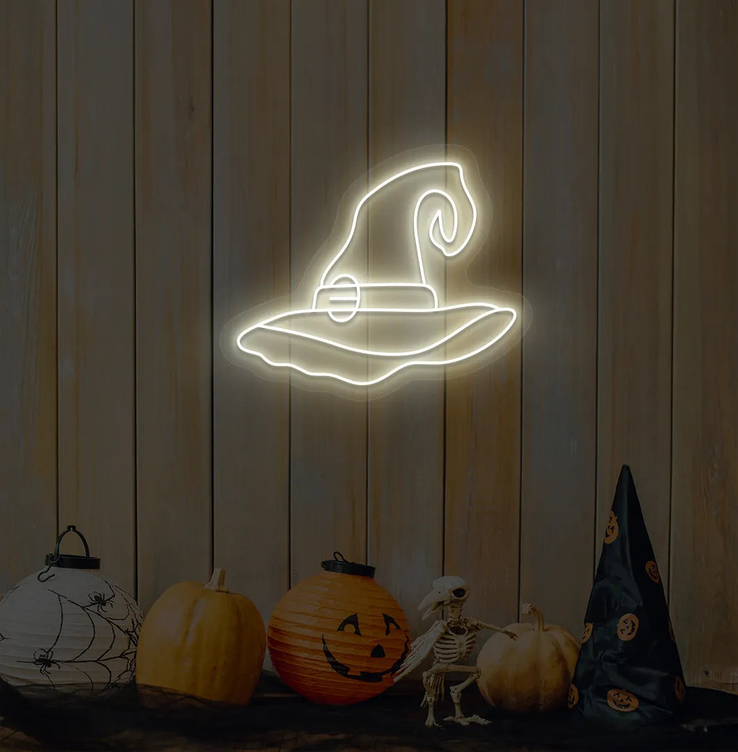 Witch Hat Neon Sign illuminated in warm white on a spooky Halloween themed wall