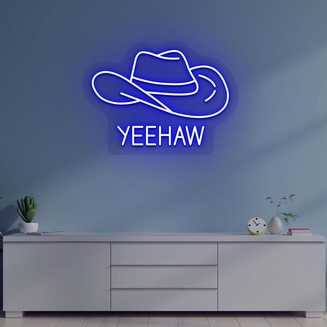 Image of a "YEEHAW" neon sign with a cowboy hat on a living room wall in blue color. 