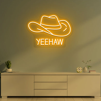 Image of a "YEEHAW" neon sign with a cowboy hat on a living room wall in orange color. 