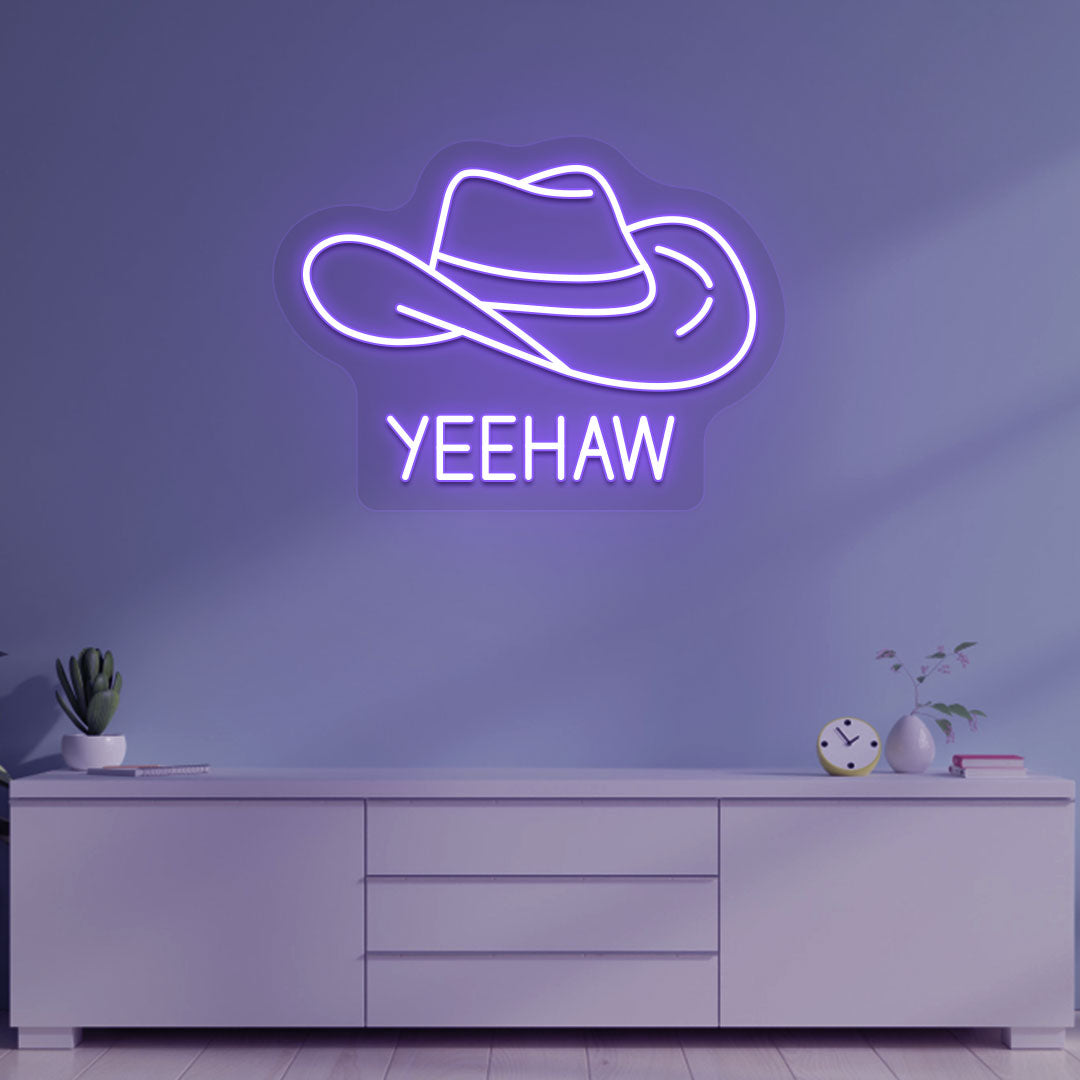 Image of a "YEEHAW" neon sign with a cowboy hat on a living room wall in purple color. 