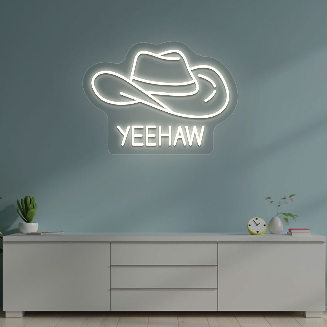 Image of a "YEEHAW" neon sign with a cowboy hat on a living room wall in warm white color. 