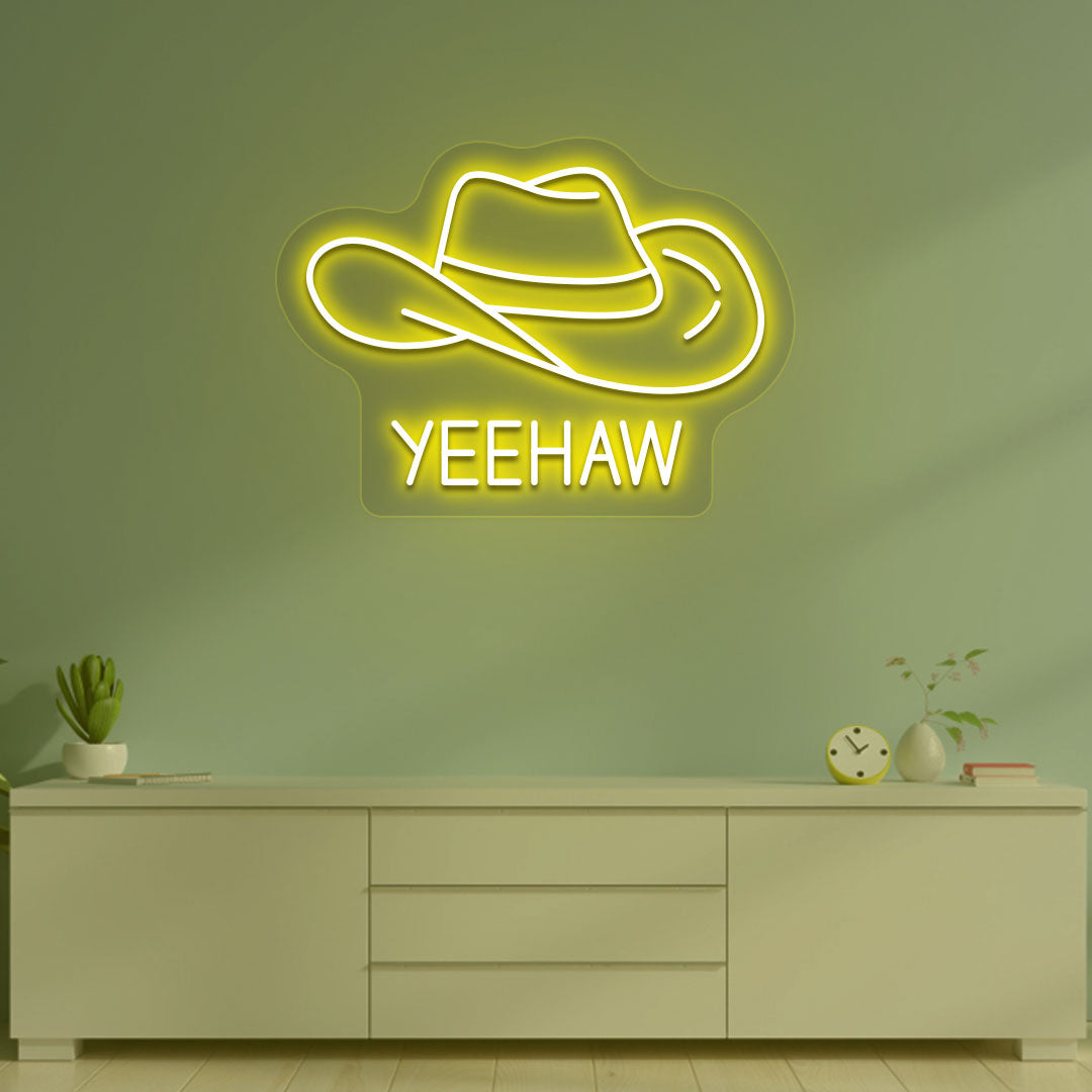 Image of a "YEEHAW" neon sign with a cowboy hat on a living room wall in yellow color. 