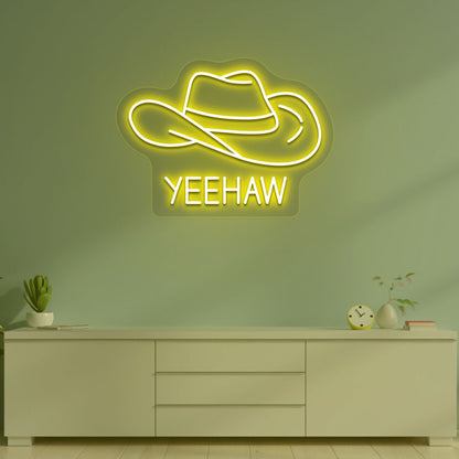 Image of a "YEEHAW" neon sign with a cowboy hat on a living room wall in yellow color. 