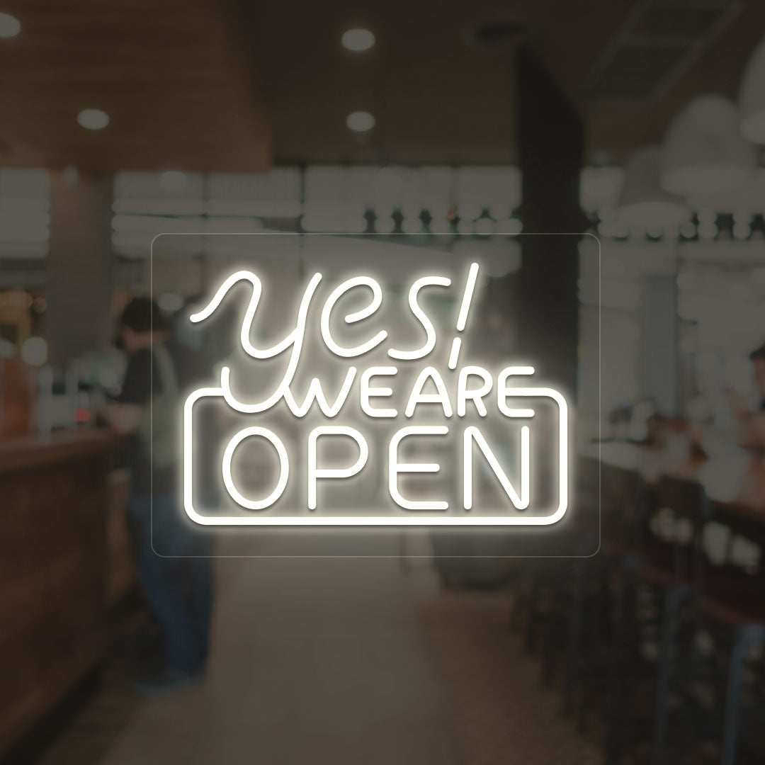 A storefront warm white LED "Yes, we are open" neon sign mounted on a glass wall. perfect for retail shops, storefronts, and restaurants.