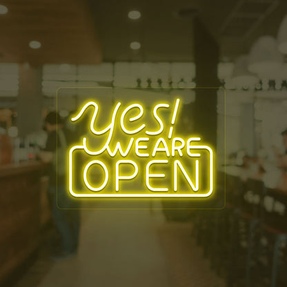 A storefront yellow LED "Yes, we are open" neon sign mounted on a glass wall. perfect for retail shops, storefronts, and restaurants.