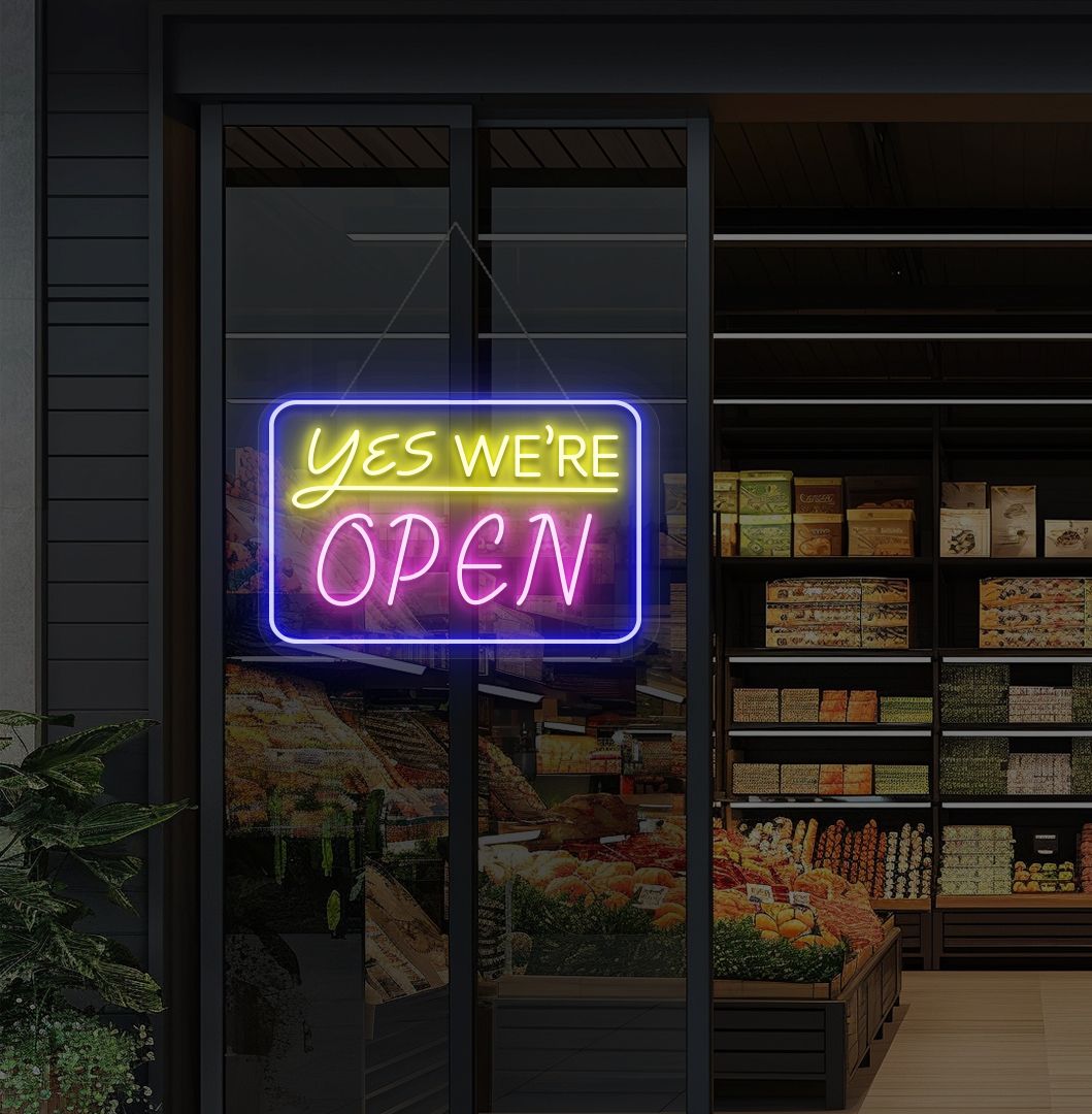 Image of a "Yes, we're open" neon sign glowing on a cafe glass door in pink color.