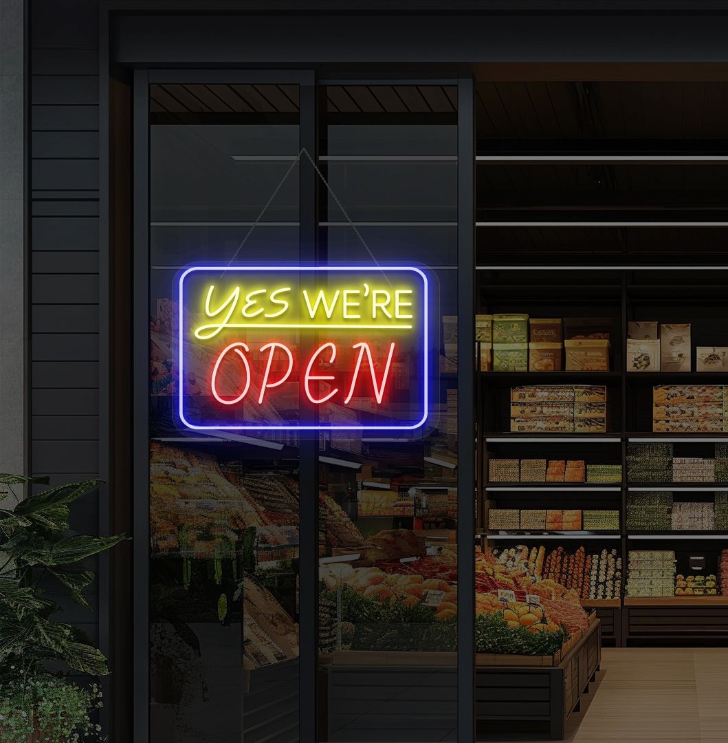 Image of a "Yes, we're open" neon sign glowing on a cafe glass door in red color.