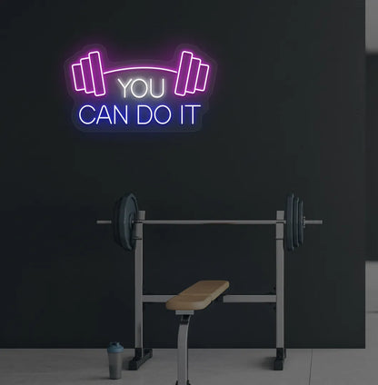 Image of a modern gym wall with you can do it dumbbell neon sign glowing blue.