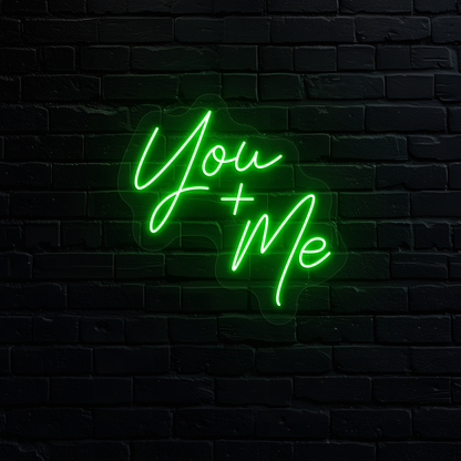 Aesthetic wall with "you plus me" neon sign glowing green.