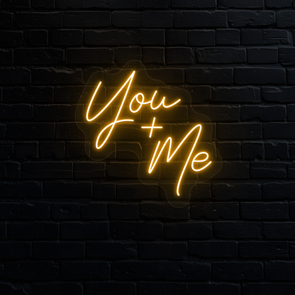 Aesthetic wall with "you plus me" neon sign glowing orange.