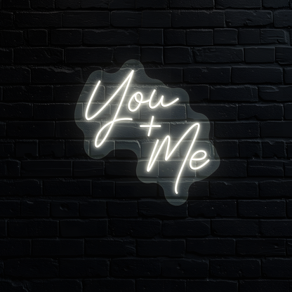Aesthetic wall with "you plus me" neon sign glowing warm white.
