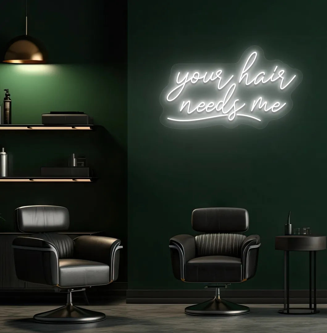 Beauty salon interior with Your Hair Needs Me neon sign glowing white.